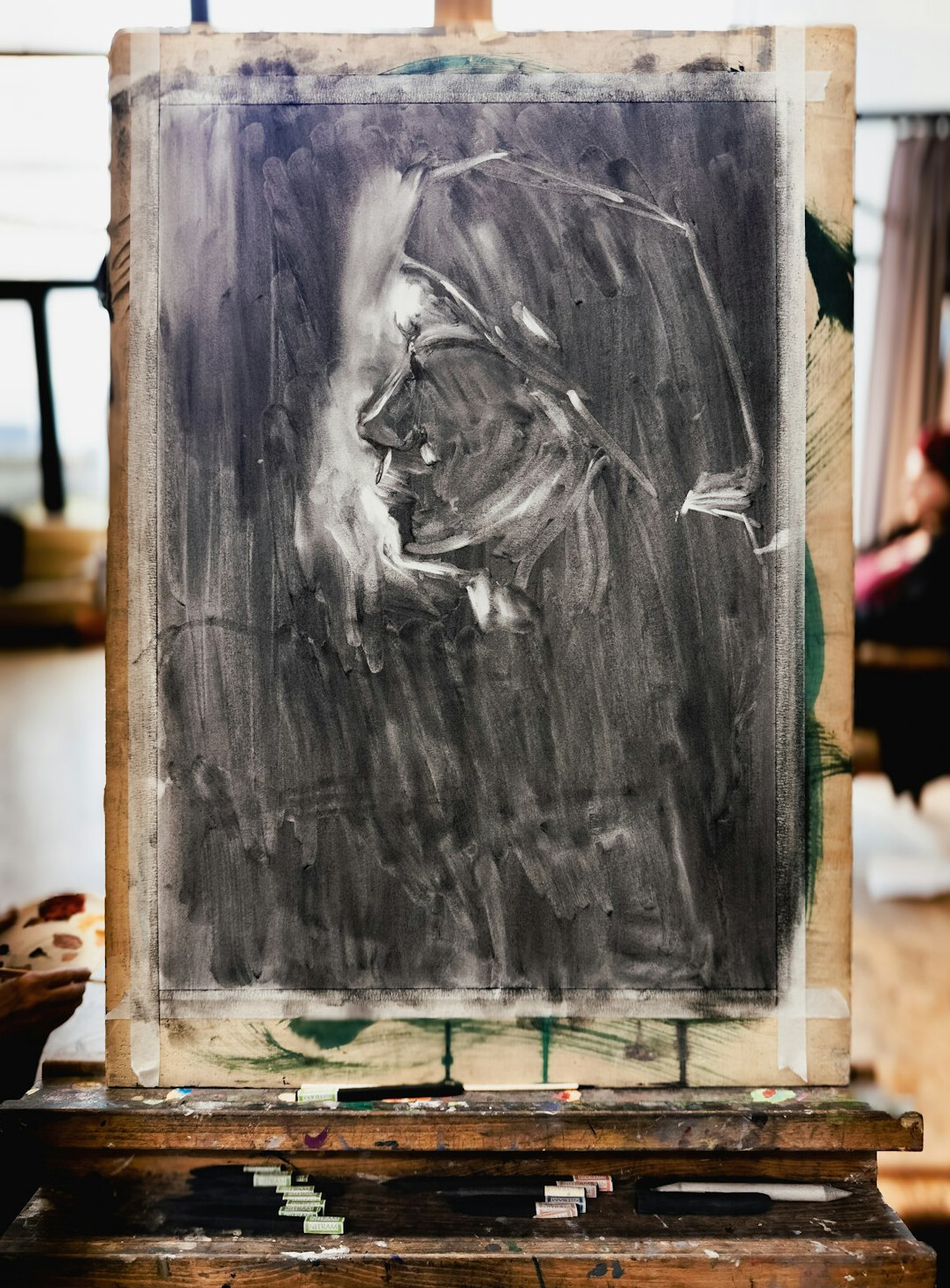 Senior man painting with watercolors at an easel in a studio