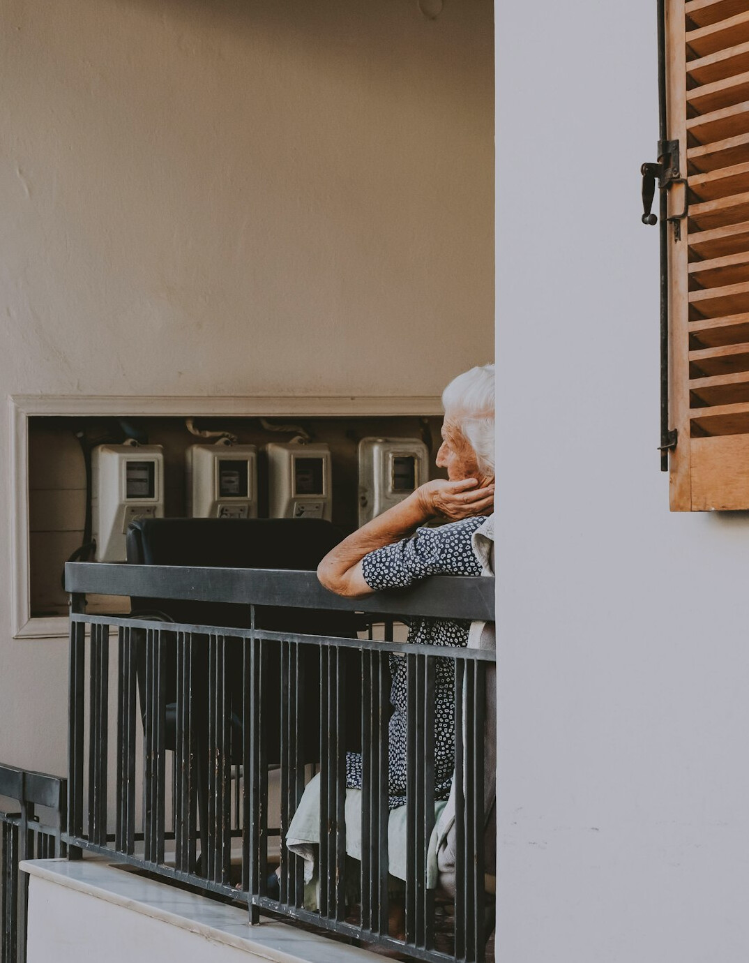 Senior woman with a silver bob haircut sitting on a sunny terrace with a cup of coffee